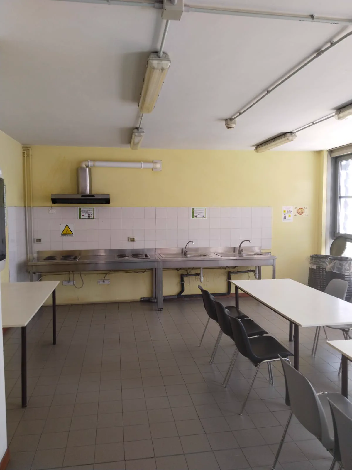 Residenza Borsellino'daki ortak mutfakta ocaklar, lavabolar ve çalışma masaları