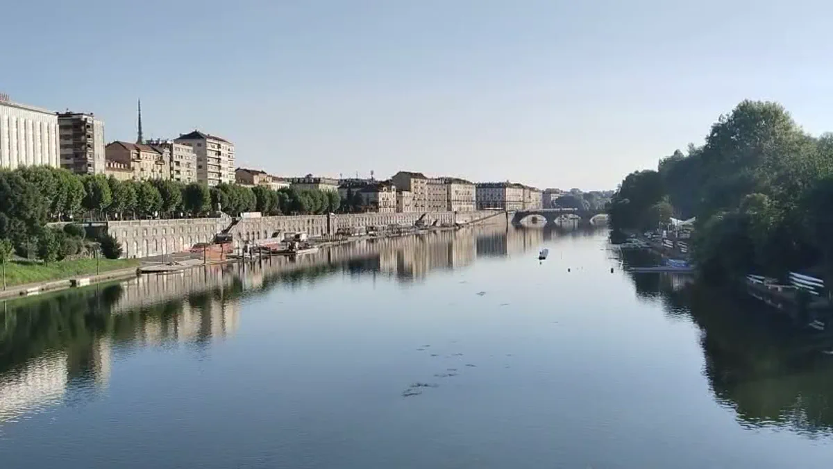 Sabah ışığında Po Nehri, kıyı binaları ve suya yansıyan ağaçlar